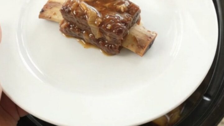 Slow cooker beef short ribs glazed in honey hickory BBQ sauce with caramelized Vidalia onions