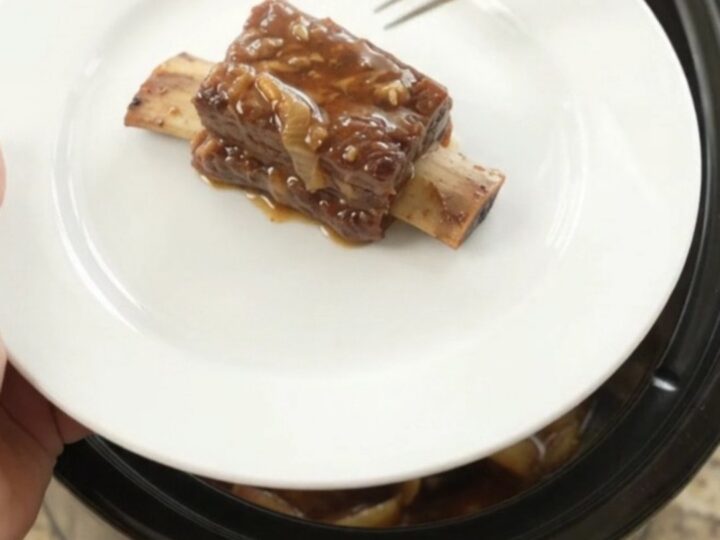 Slow cooker beef short ribs glazed in honey hickory BBQ sauce with caramelized Vidalia onions