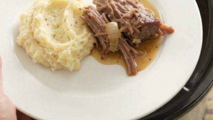 Shredded beef chuck roast with mushrooms in a buttery jus in a slow cooker.