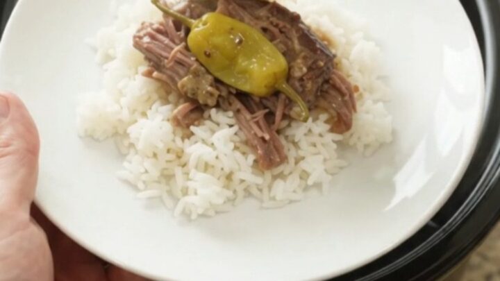 Shredded pepperoncini ranch chuck roast in a slow cooker with creamy sauce
