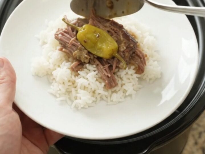 Shredded pepperoncini ranch chuck roast in a slow cooker with creamy sauce