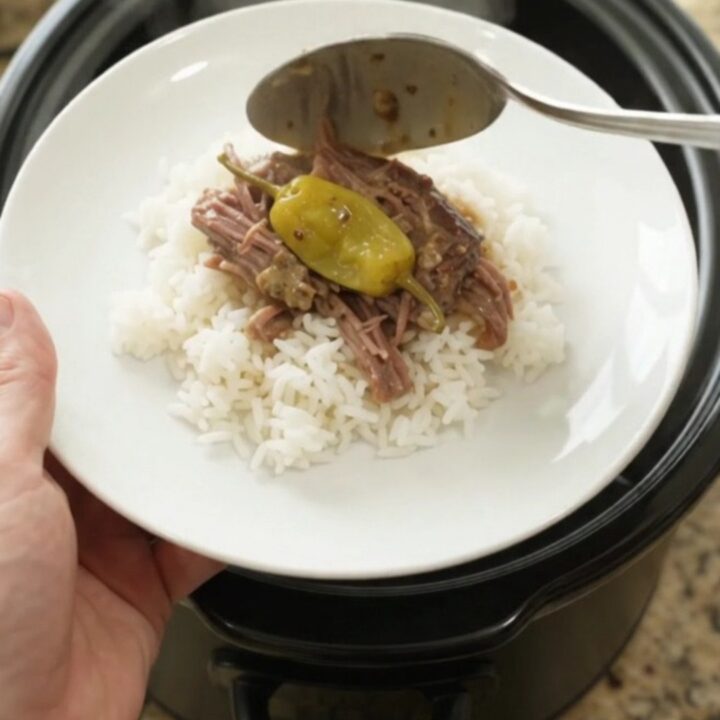 Shredded pepperoncini ranch chuck roast in a slow cooker with creamy sauce