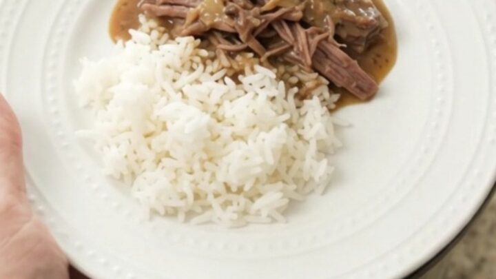 Slow cooker chuck roast with mushrooms and creamy Dijon gravy in a black crockpot