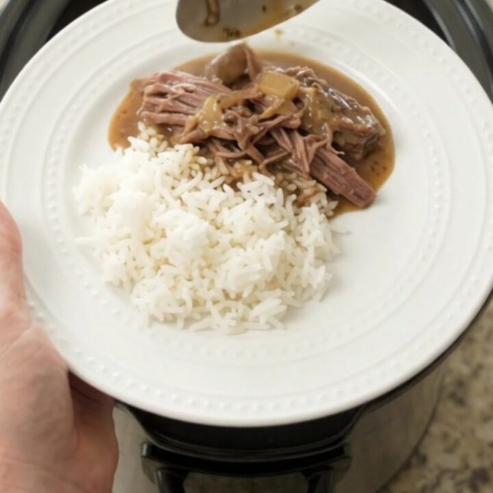 Slow cooker chuck roast with mushrooms and creamy Dijon gravy in a black crockpot
