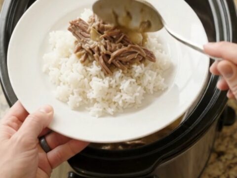 Shredded beef chuck roast with pearl onions in creamy Guinness gravy in a slow cooker.