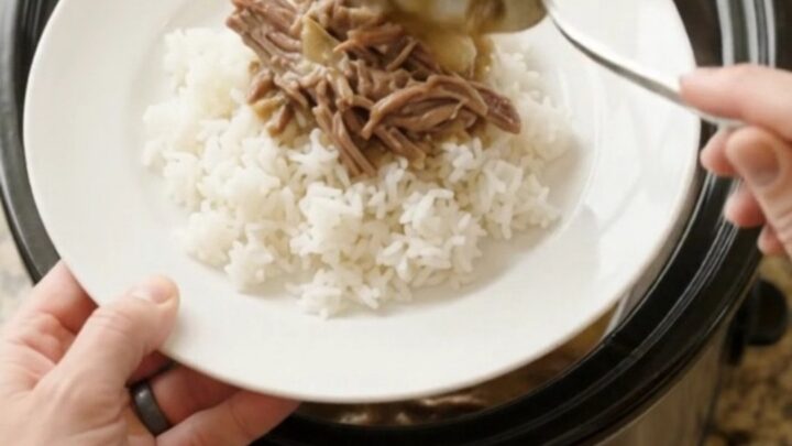 Shredded beef chuck roast with pearl onions in creamy Guinness gravy in a slow cooker.