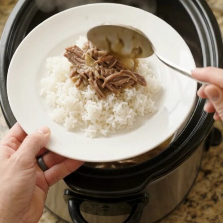 Shredded beef chuck roast with pearl onions in creamy Guinness gravy in a slow cooker.