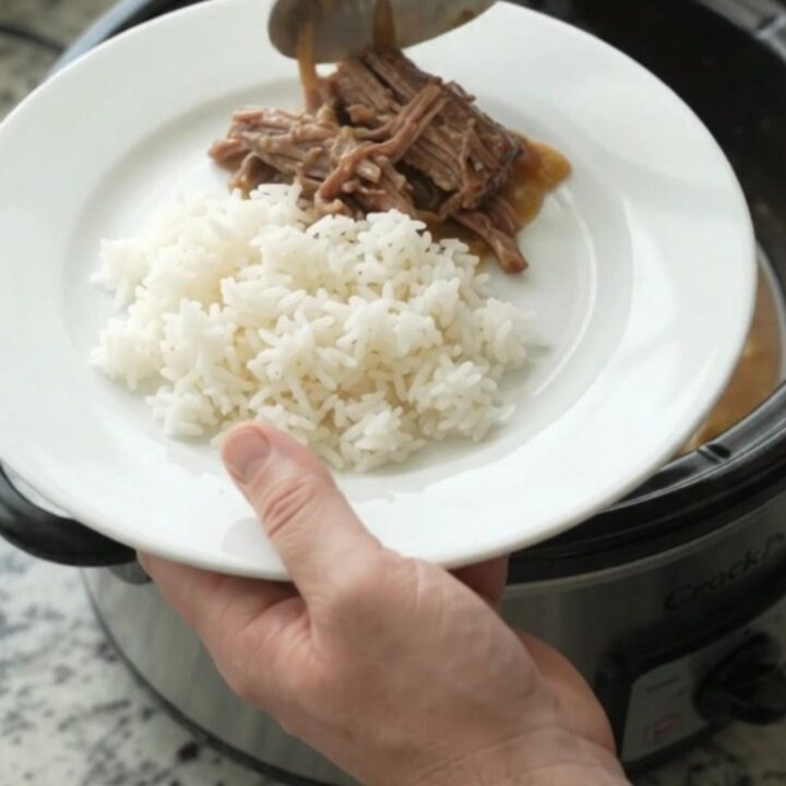 Shredded beef chuck roast with caramelized onions and creamy Dijon sauce in a slow cooker