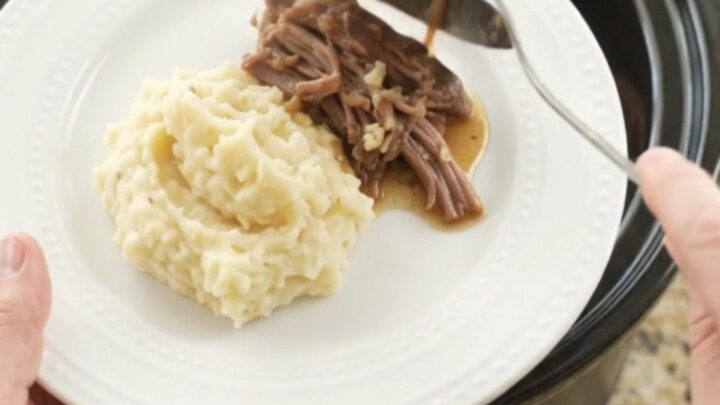 Shredded beef chuck roast with portobello mushrooms and golden butter jus in a slow cooker