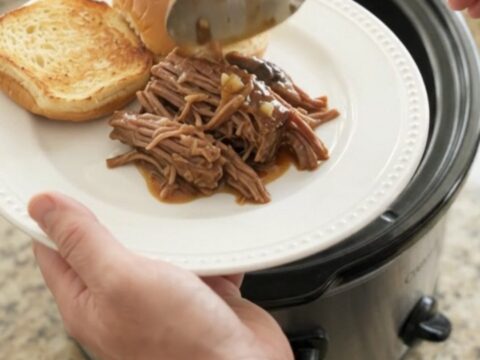 Shredded beef chuck roast with portobello mushrooms in rich brown gravy in a slow cooker