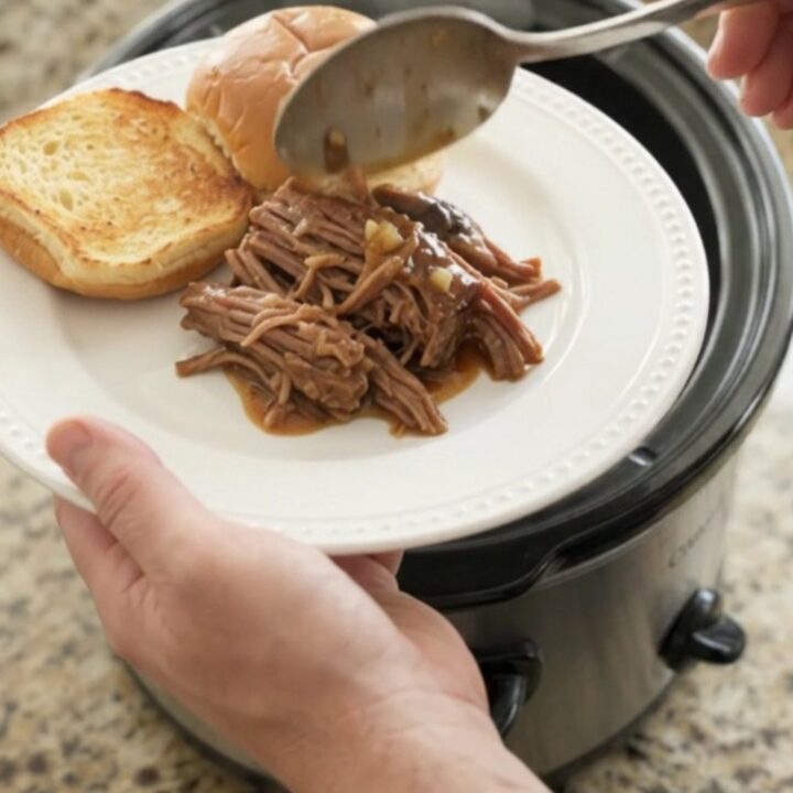 Shredded beef chuck roast with portobello mushrooms in rich brown gravy in a slow cooker