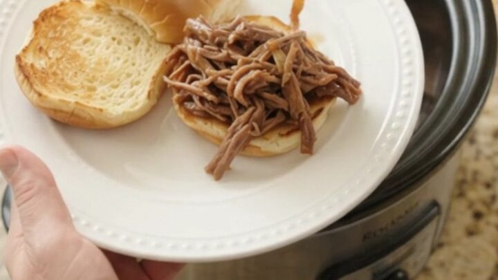Shredded chuck roast in rich gravy with sweet peppers and onions in a slow cooker