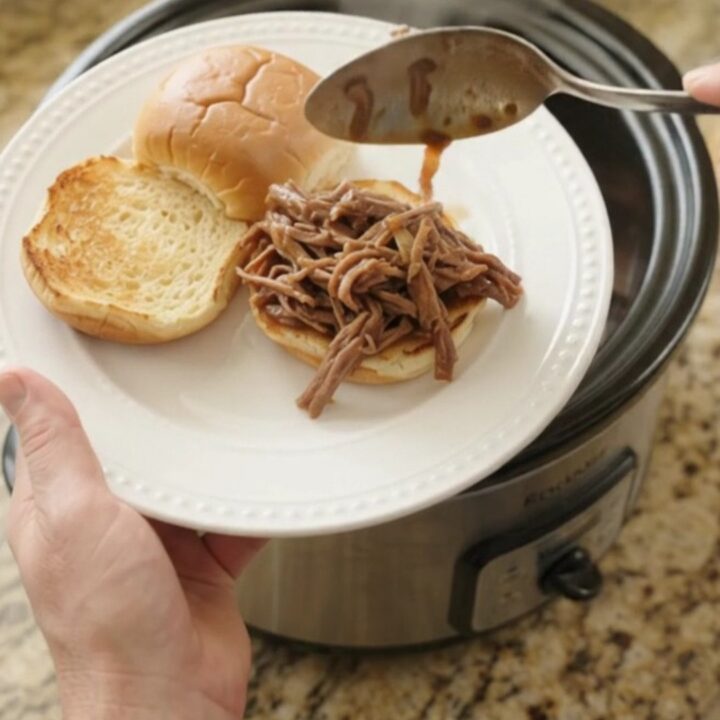 Shredded chuck roast in rich gravy with sweet peppers and onions in a slow cooker