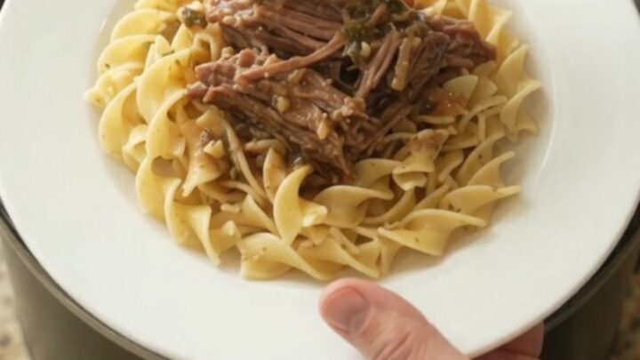 Shredded beef chuck roast with peppers and onions in a slow cooker