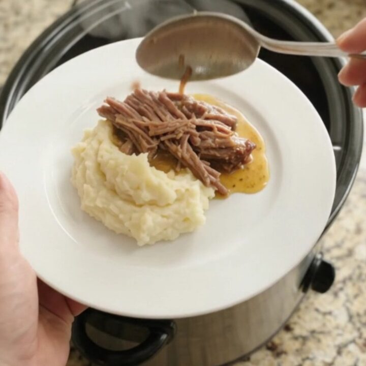 Slow cooker brisket with pepperoncini and butter sauce in a black crockpot