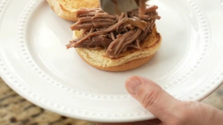 Slow-cooker beef brisket with mushrooms in rich gravy, served on a white plate