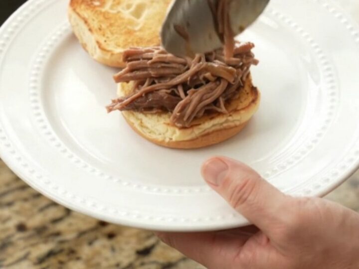 Slow-cooker beef brisket with mushrooms in rich gravy, served on a white plate