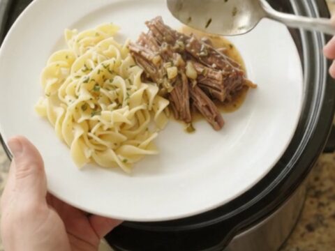 Fork-tender shredded beef brisket in rich garlic-herb gravy in a slow cooker