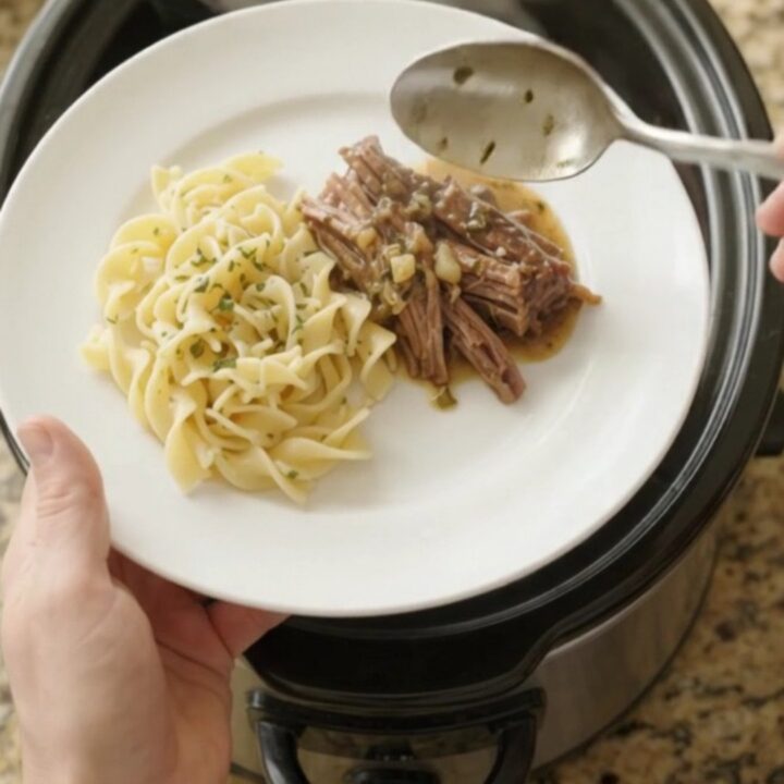 Fork-tender shredded beef brisket in rich garlic-herb gravy in a slow cooker