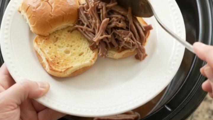 Shredded beef brisket in rich brown gravy with pearl onions in a slow cooker