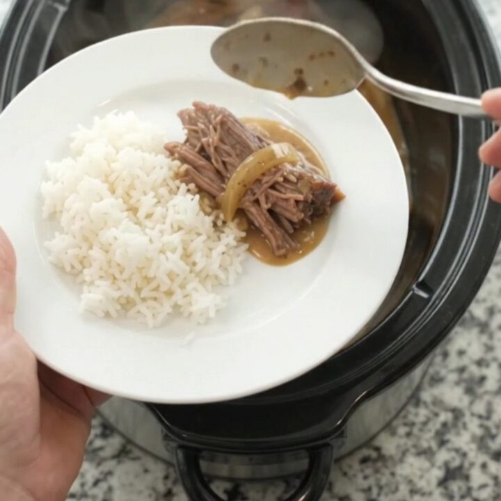Slow-cooked beef brisket in creamy Dijon sauce with caramelized onions in a black crockpot