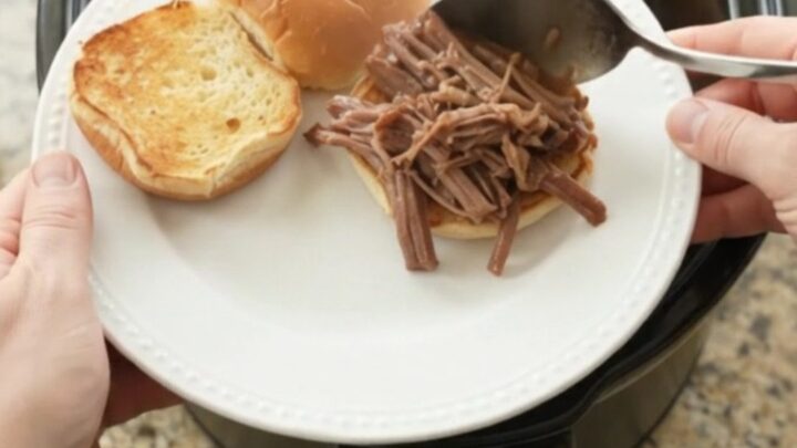 Slow-cooker beef brisket with shallots and carrots in rich gravy, served on a plate