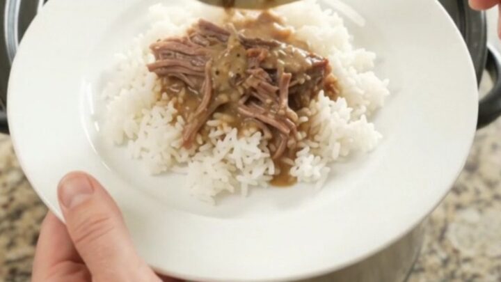Slow cooker brisket with creamy Dijon sauce, shallots, and carrots in a black crockpot