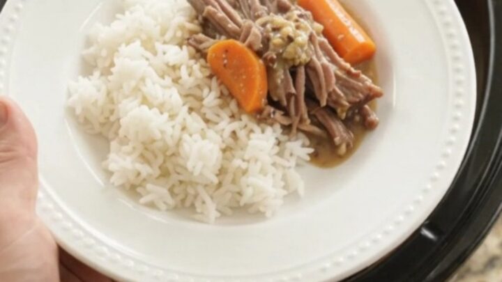 Slow-cooker brisket with potatoes and carrots in creamy Dijon gravy, in a black ceramic pot