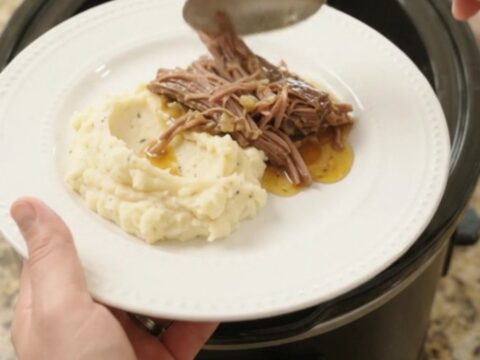 Shredded beef brisket with mushrooms and butter jus in a slow cooker