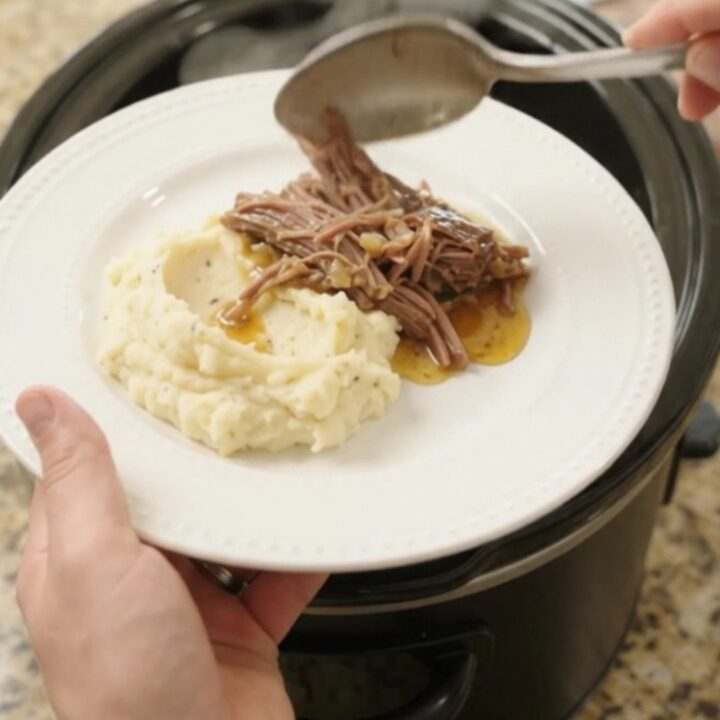 Shredded beef brisket with mushrooms and butter jus in a slow cooker