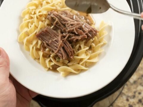 Shredded beef brisket with peppers and onions in a slow cooker