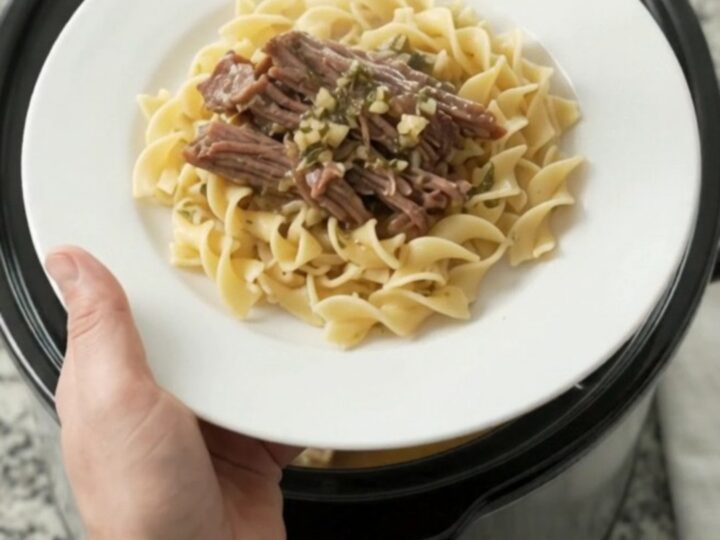 Slow-cooker beef brisket with portobello mushrooms and garlic butter gravy in a black crockpot
