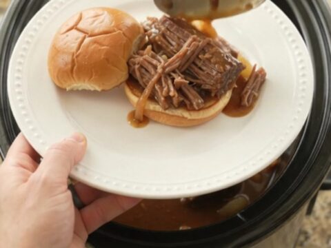Slow cooker beef brisket with sweet peppers and onions in rich brown gravy, ready to serve