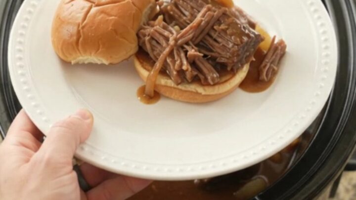 Slow cooker beef brisket with sweet peppers and onions in rich brown gravy, ready to serve