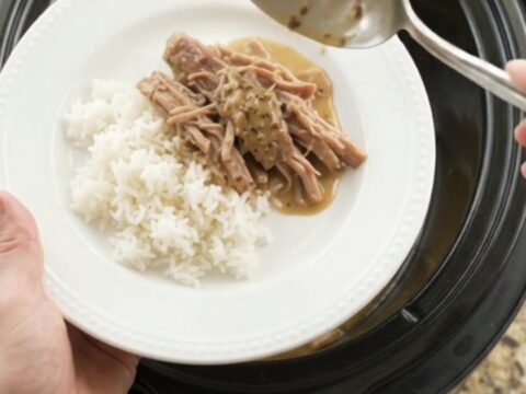 Slow-cooker pork shoulder with pepperoncini and creamy gravy in a black pot