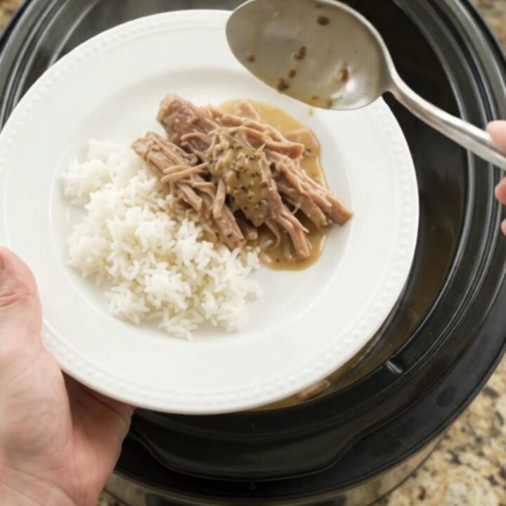 Slow-cooker pork shoulder with pepperoncini and creamy gravy in a black pot