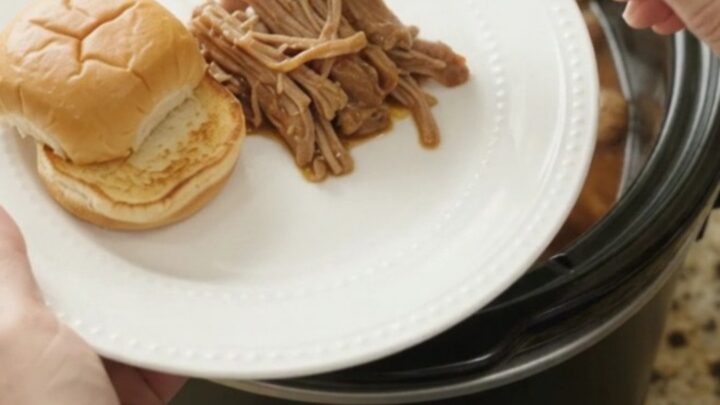 Shredded pork shoulder with mushrooms and gravy in a slow cooker