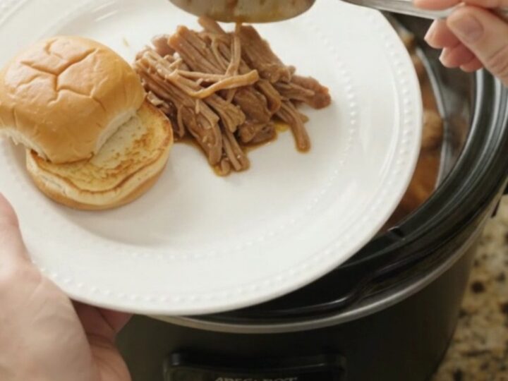 Shredded pork shoulder with mushrooms and gravy in a slow cooker