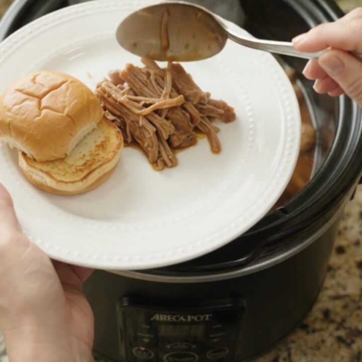 Shredded pork shoulder with mushrooms and gravy in a slow cooker