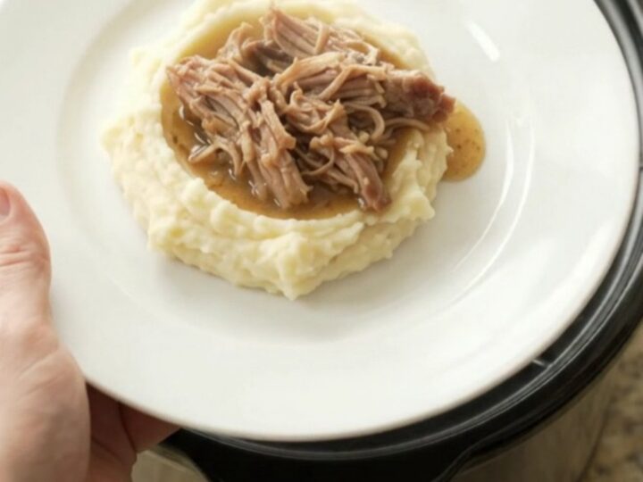 Shredded pork shoulder with mushrooms and butter sauce in a slow cooker