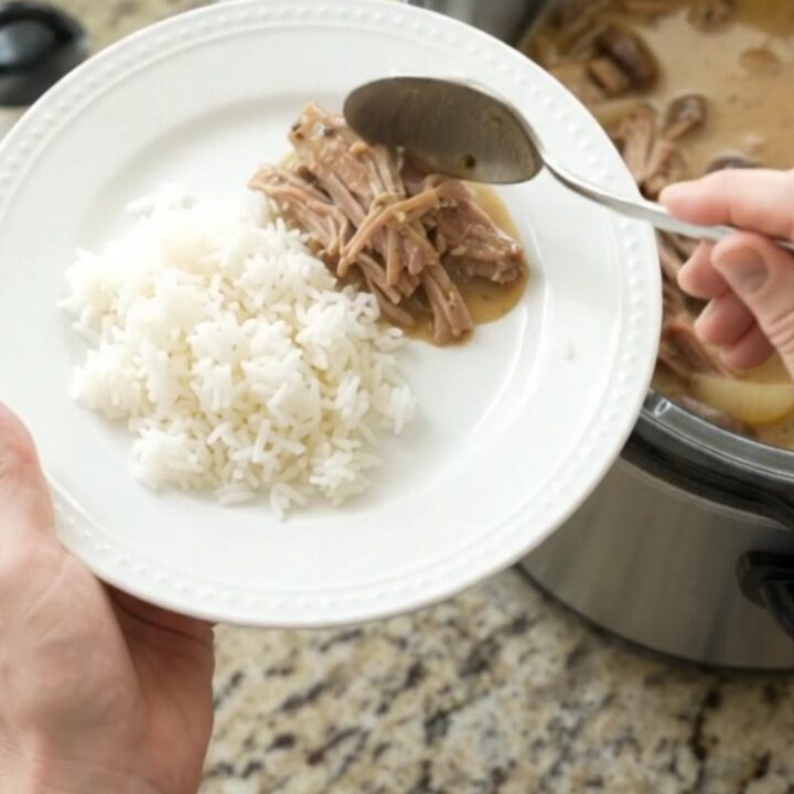 Shredded pork shoulder with mushrooms in creamy Dijon sauce in a slow cooker