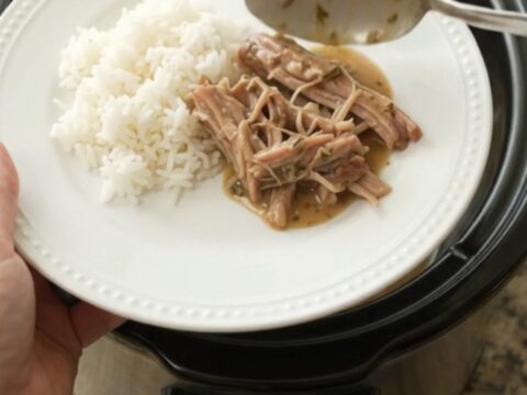 Slow-cooked pork shoulder with creamy Dijon gravy in a black crockpot