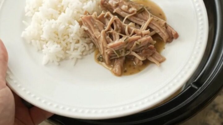 Slow-cooked pork shoulder with creamy Dijon gravy in a black crockpot
