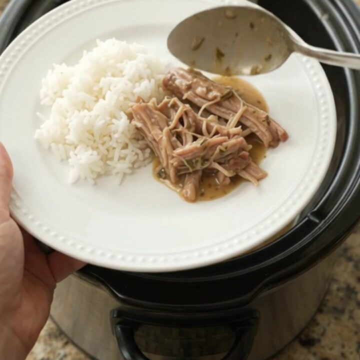 Slow-cooked pork shoulder with creamy Dijon gravy in a black crockpot