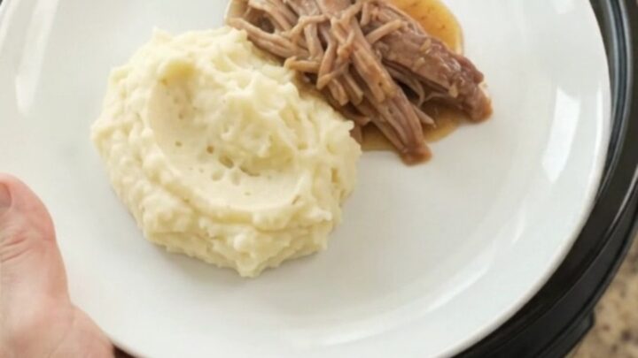 Shredded pork shoulder with pearl onions in a buttery Guinness jus in a slow cooker
