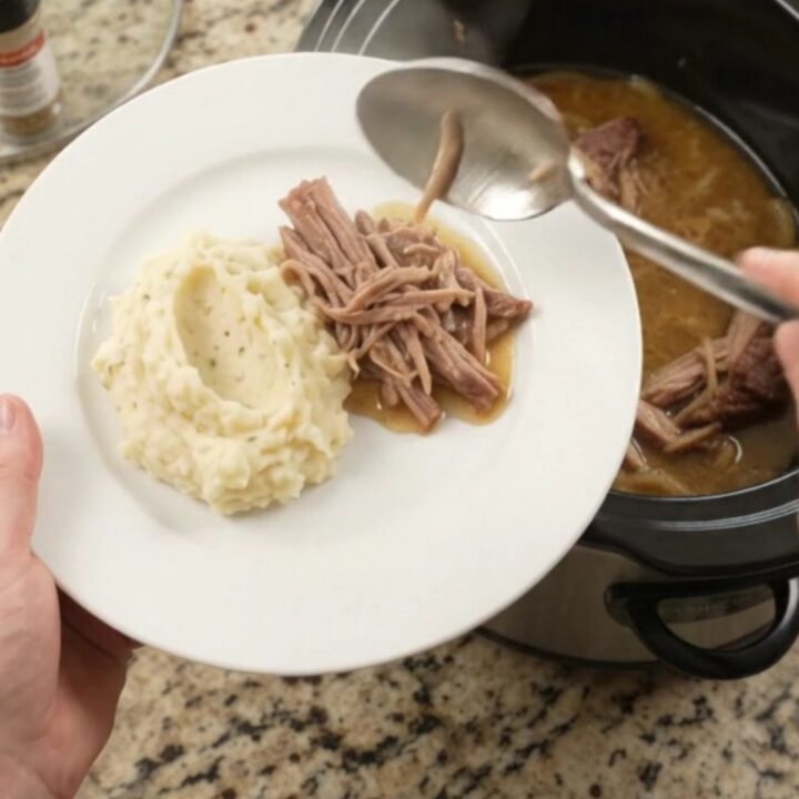 Slow cooker French onion butter pork shoulder with caramelized onions and buttery jus