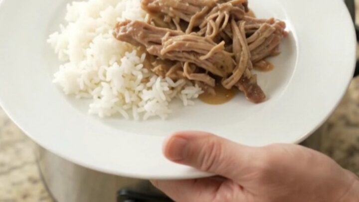 Shredded pork shoulder in creamy Guinness Dijon gravy with pearl onions in a slow cooker