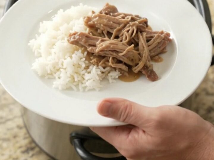 Shredded pork shoulder in creamy Guinness Dijon gravy with pearl onions in a slow cooker