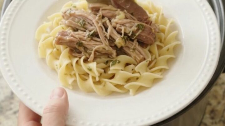 Slow-cooked pork shoulder with garlic and herbs in a black crockpot