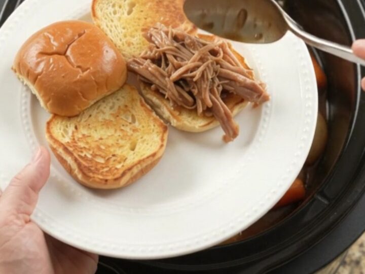 Slow-cooker pork shoulder with shallots and carrots in rich brown gravy, ready to serve